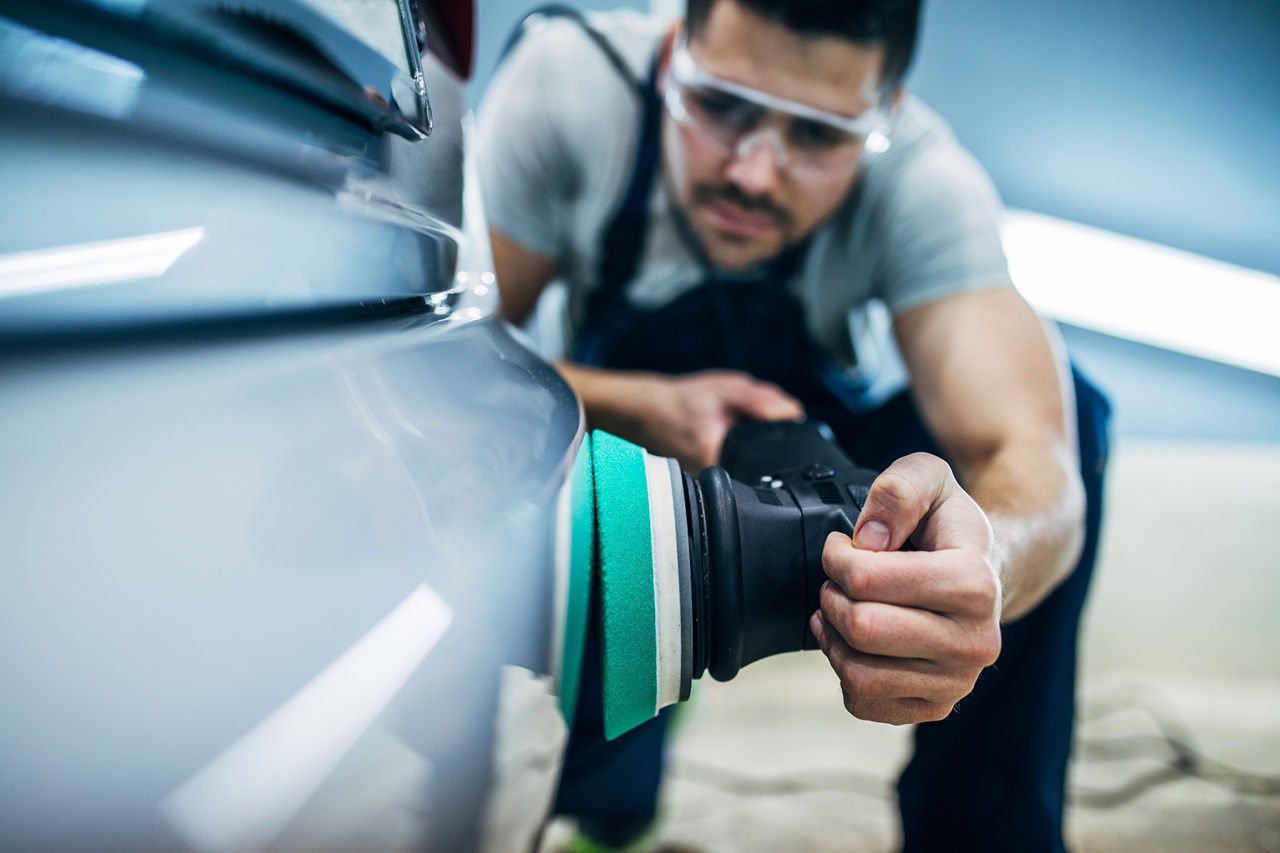 Man doing a car polish with a machine.